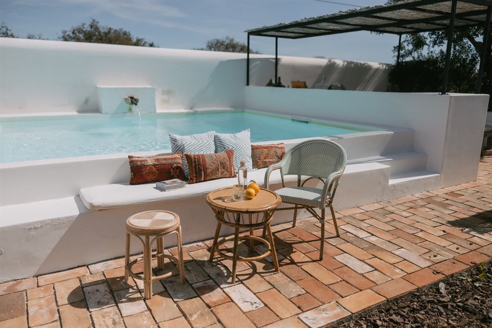 piscina con muebles de ratán natural y ratán sintético